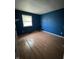 Bedroom with dark blue walls, wood flooring, and natural light from the window at 3231 W State Road 32, Westfield, IN 46074