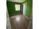 Empty bedroom featuring hardwood floors, green painted walls and a window at 3231 W State Road 32, Westfield, IN 46074