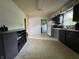 Kitchen with dark cabinetry, appliances, and tile floor; utility area in background at 3231 W State Road 32, Westfield, IN 46074