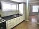 Kitchen with white cabinets, dark countertops, double sink, and view of another room at 309 S Fleming St, Indianapolis, IN 46241