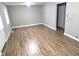 Open living room featuring wood-look flooring, neutral walls, and a ceiling light at 309 S Fleming St, Indianapolis, IN 46241