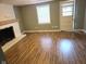 Living room featuring a fireplace with white brick surround and wood-look floors at 309 S Fleming St, Indianapolis, IN 46241