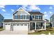 Two-story gray house with white garage doors, stone accents, and a covered porch at 250 Mcnair Rd, Whiteland, IN 46184