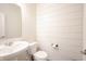 Clean half bathroom features modern vanity, toilet, and horizontal shiplap on the wall at 5573 Mahogany Dr, Noblesville, IN 46062