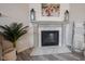 Elegant fireplace with white mantel, marble tile and decorative lanterns and a plant at 5573 Mahogany Dr, Noblesville, IN 46062