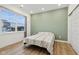 Modern bedroom featuring a light green accent wall, plank flooring, and a large window with plenty of natural light at 10008 Sundley Dr, Indianapolis, IN 46239