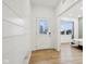 Bright entryway with white shiplap walls, light wood floors, and a view of the front door and other rooms at 10008 Sundley Dr, Indianapolis, IN 46239
