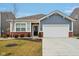 Charming single-story home with blue siding, brick accents, a two-car garage, and a well-manicured front yard at 10008 Sundley Dr, Indianapolis, IN 46239