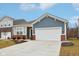 Charming single-story home with blue siding, brick accents, a two-car garage, and a well-manicured front yard at 10008 Sundley Dr, Indianapolis, IN 46239