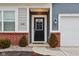 The front of the home features a black front door with sidelights and manicured landscaping and brick accents at 10008 Sundley Dr, Indianapolis, IN 46239