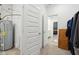 Hallway featuring closet doors, water heater, and an open doorway to the bedroom at 10008 Sundley Dr, Indianapolis, IN 46239