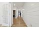 Hallway with plank flooring and a view into a bedroom, featuring a shiplap accent wall at 10008 Sundley Dr, Indianapolis, IN 46239