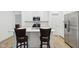 Bright kitchen boasts stainless steel appliances, white cabinetry, and convenient island seating at 10008 Sundley Dr, Indianapolis, IN 46239