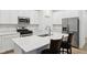 This modern white kitchen boasts stainless appliances, sleek countertops and a convenient island with barstool seating at 10008 Sundley Dr, Indianapolis, IN 46239