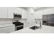 Modern kitchen featuring white cabinets, stainless appliances, sleek countertops, and ample counter space for cooking at 10008 Sundley Dr, Indianapolis, IN 46239