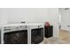 Modern laundry room featuring white washer and dryer units, complemented by sleek black cabinets at 10008 Sundley Dr, Indianapolis, IN 46239