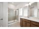 This bathroom includes dual sinks, wooden cabinetry, a tiled shower with glass door, and a closet at 15846 Vitalize Run, Fishers, IN 46040