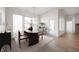 Dining room featuring large windows, light wood floors, table, chairs and modern lighting at 15846 Vitalize Run, Fishers, IN 46040