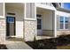 Inviting front porch with stone pillars, complementing the home's stylish exterior, leading to the entry at 15846 Vitalize Run, Fishers, IN 46040