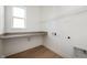 Laundry room features a gray countertop, white walls and trim, and wood-look flooring at 15846 Vitalize Run, Fishers, IN 46040