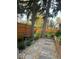 Serene backyard with a stone pathway leading to a deck, surrounded by mature trees and lush landscaping at 6906 Johnson Rd, Indianapolis, IN 46220