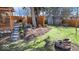 View of backyard featuring a wooden fence, fire pit, storage shed, mulched flower beds, and a small deck with seating at 6906 Johnson Rd, Indianapolis, IN 46220