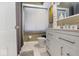 Well-lit bathroom with white vanity, modern fixtures, and white tile flooring at 6906 Johnson Rd, Indianapolis, IN 46220