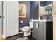 Stylish half-bathroom featuring a dark vanity and matching dark floors at 6906 Johnson Rd, Indianapolis, IN 46220