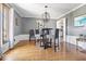 Dining area featuring hardwood floors, natural light, and a stylish modern chandelier at 6906 Johnson Rd, Indianapolis, IN 46220