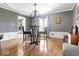 Cozy dining room with hardwood floors, modern light fixture, wainscoting, and neutral gray walls at 6906 Johnson Rd, Indianapolis, IN 46220