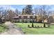 Charming stone-clad home featuring a well-manicured lawn and an asphalt driveway at 6906 Johnson Rd, Indianapolis, IN 46220