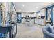 Bright eat-in kitchen with white cabinets, island with seating, stainless appliances, and gray tile at 6906 Johnson Rd, Indianapolis, IN 46220
