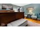 Bedroom with hardwood floors, a plush bed, seating area, and stylish decor at 6906 Johnson Rd, Indianapolis, IN 46220