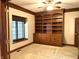 Home office featuring custom built-in wooden bookshelves, soft lighting, and large window at 1079 Old Eagle Way, Greenwood, IN 46143