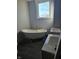 Bathroom boasts a clawfoot tub, dual sink vanity, gray ceramic tile, and a bright window at 201 W Walnut St, Waldron, IN 46182
