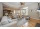 Inviting living room boasts hardwood floors, neutral tones, ceiling fan, and a sun-drenched sitting area at 15571 Bridgewater Club Blvd, Carmel, IN 46033