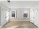 A sunny bedroom showing two windows, two doors, fresh paint, baseboards and wood-look floors at 1429 Brookside Pkwy N Dr, Indianapolis, IN 46201