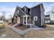 Two-story home with brick and siding exterior and concrete steps has a welcoming appeal at 1429 Brookside Pkwy N Dr, Indianapolis, IN 46201