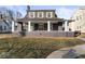 Charming two-story home featuring a large covered front porch, decorative shutters, and landscaped yard at 1429 Brookside Pkwy N Dr, Indianapolis, IN 46201