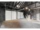 Interior view of a two car garage with white doors and walls, concrete floor, and overhead lights at 1429 Brookside Pkwy N Dr, Indianapolis, IN 46201