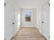 Hallway features fresh white paint, baseboards, wood-look floors, two doors, and a window at 1429 Brookside Pkwy N Dr, Indianapolis, IN 46201