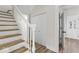 Hallway with painted staircase features wood stairs and flooring and white trim and doors at 1429 Brookside Pkwy N Dr, Indianapolis, IN 46201