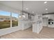 Eat-in kitchen with island, white cabinets, and backyard view at 4996 Hummingbird Dr, Brownsburg, IN 46112
