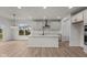 Modern kitchen with island, white cabinets, and hardwood floors at 4996 Hummingbird Dr, Brownsburg, IN 46112