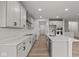 White kitchen with stainless steel appliances and hardwood floors at 4996 Hummingbird Dr, Brownsburg, IN 46112