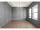 Bright dining room with gray wainscoting, hardwood floors, and a modern chandelier at 1433 Chatham Hills Blvd, Westfield, IN 46074