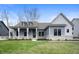 Charming single-Gathering home featuring stone accents, gray siding, covered entry, and a well-manicured lawn at 1433 Chatham Hills Blvd, Westfield, IN 46074
