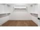 Bright, walk-in closet featuring wood floor and white shelving at 11896 Spring Mill Rd, Carmel, IN 46032