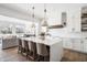 Modern kitchen with a large island, pendant lighting, and stainless steel appliances, open to living area at 11896 Spring Mill Rd, Carmel, IN 46032
