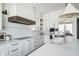 Sleek kitchen featuring white cabinets, marble countertops, stainless appliances, and modern hood at 11896 Spring Mill Rd, Carmel, IN 46032